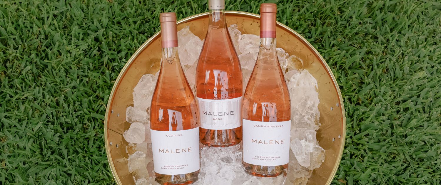 image of three bottles of Malene wine in an ice bucket with grass behind.