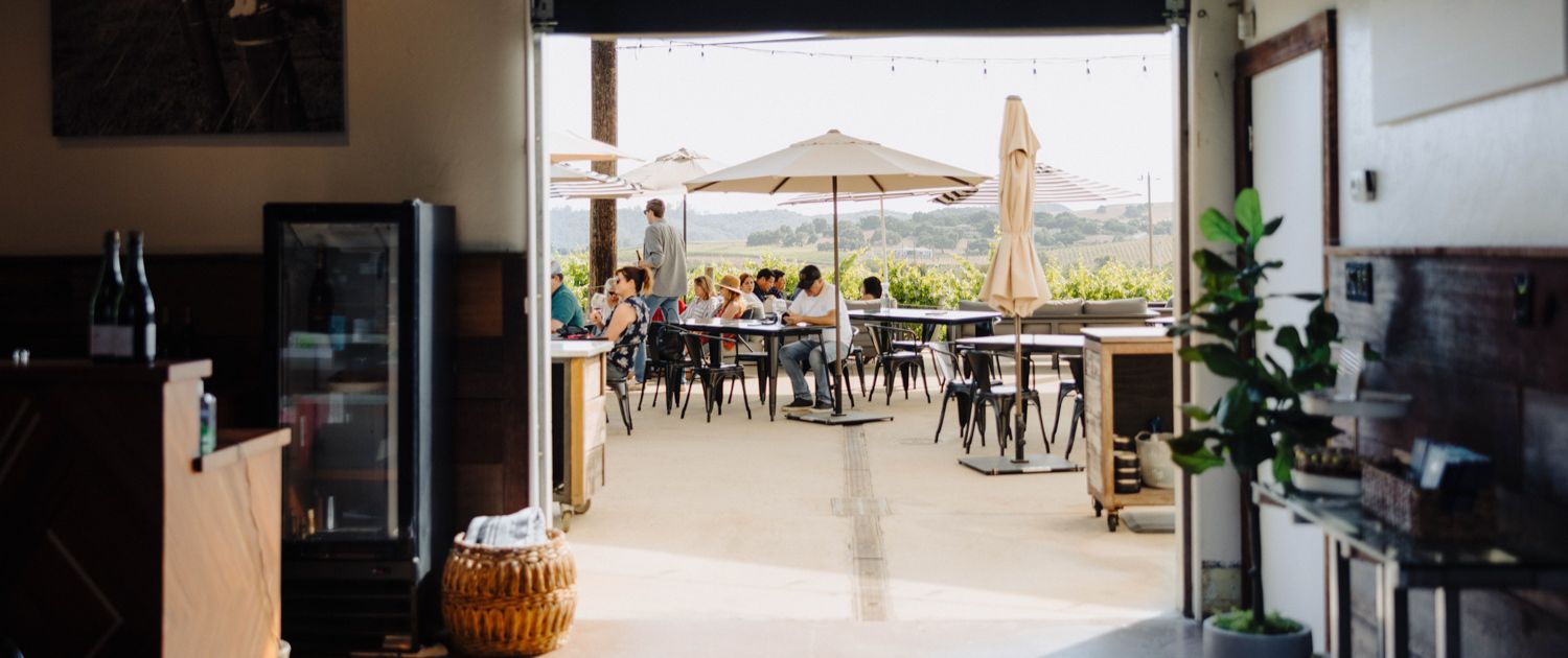 a picture of Chamisal's estate patio from the perspective of being inside the tasting room.